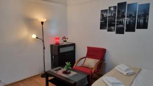 a living room with a couch and a red chair at Feeria National Parc in Bucharest