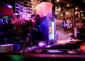 a bar with a vase of flowers on a counter at Hotel 55 - City Centre in Amsterdam