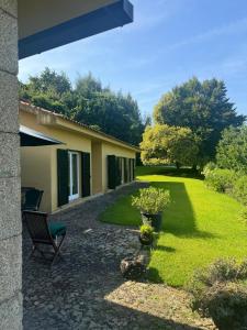 a garden with a chair and a building at Quinta da Ponte in Resende