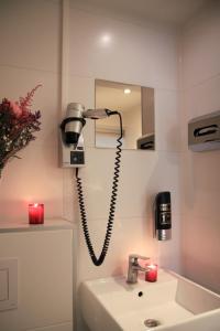 a bathroom with a phone on the wall next to a sink at Hotel 55 - City Centre in Amsterdam +92 photos