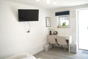 Götzendorf an der LeithaEco Overnight Inn - Self Check-in的客厅配有桌子和墙上的电视