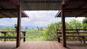 a porch with benches and a view of a field at Chakerpor rice terrace in Ban Mae Sapok Noi
