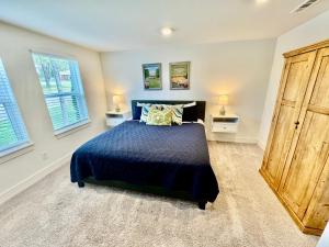 una camera con un letto blu e due finestre di 4br Game Room 6 Beds Family, Opry & Bway a Nashville