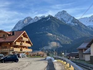a mountain with cars parked on a road with a building at 3 bedroom Modern Alpine Escape in Chateau-d'Oex