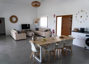 a kitchen and living room with a wooden table and chairs at Casa Rural La Yesería Alcocer in Sacedón
