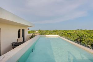 a swimming pool on the side of a house at Alberca y balcon privado a 6 minutos de la playa in Tulum