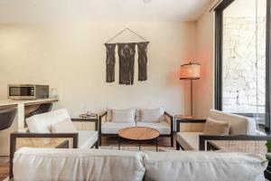 a living room with a couch and a table at Alberca y balcon privado a 6 minutos de la playa in Tulum