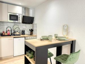 a kitchen with a table with dishes on it at Le Jardin de la Cathédrale - T2 - Centre Ville - Emplacement & Vue Extraordinaires in Narbonne