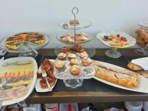 a table topped with plates of food and pastries at L'Approdo delle Sirene in Syracuse