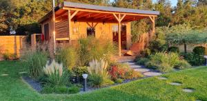 a garden with a wooden pavilion in a yard at Sjesta al mare, domki z sauną i balią z jacuzzi in Lubiatowo +209 photos