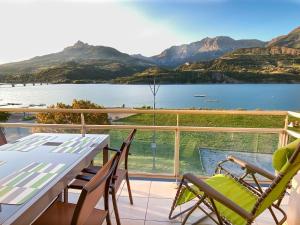 a balcony with a view of a lake and mountains at La terrasse au bord du Lac, vue panoramique lac et montagnes , 2 ch, linge et ménage inclus in Savines
