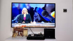 a television screen with a microphone on a table at Apartment Centar in Podgorica
