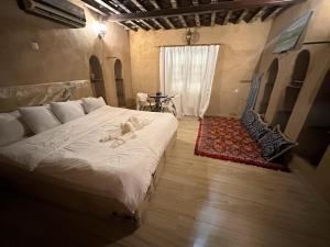 una camera da letto con un grande letto con una donna sdraiata sopra di Al-Ghanima Rest House a Al Ḩamrāʼ