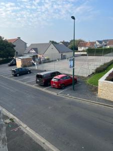 a group of cars parked in a parking lot at Maisonnette de charme 42m2, centre village Vierville-sur-Mer in Vierville-sur-Mer +5 photos