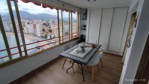 a table and chairs in a room with a large window at Las mejores vistas de benidorm. in Benidorm