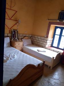 Postel nebo postele na pokoji v ubytování Les Pyramides Hotel Merzouga