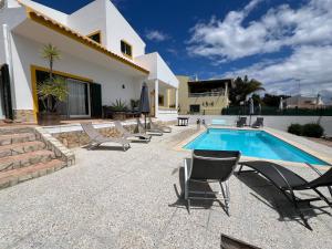 a villa with a swimming pool and lounge chairs at Villa Balsa in Tavira