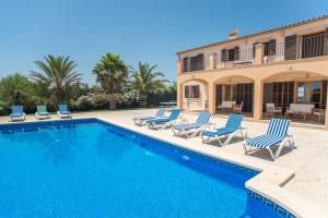 una piscina con tumbonas y una casa en Finca Romana, en S'Horta