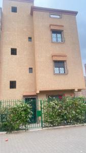 a large building with two windows and a fence at Aéroport studio Marrakech in Marrakech