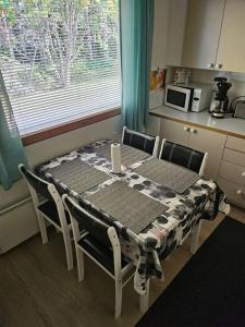 a kitchen with a table and chairs with a table and a window at Mäntypää, keskellä Vuokattia in Vuokatti +11 photos