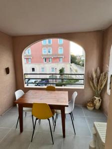 a dining room with a table and chairs and a window at Appartement Les Terrasses du Port in Port-de-Bouc