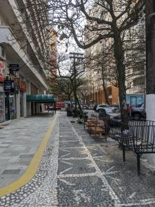a sidewalk with benches on a city street at 2U TOUR - Guarujá perfeito in Guarujá +20 photos