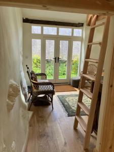 una habitación con una escalera y una silla y una puerta en Studio in medieval Welsh farmhouse, en Aber Cowarch