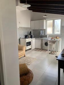 eine Küche mit weißen Schränken und einem Tisch darin in der Unterkunft SERMAR 1 in Rabo de Peixe