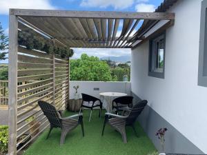 a patio with chairs and a table and a fence at SERMAR 1 in Rabo de Peixe