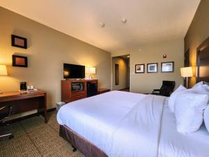 a hotel room with a bed and a desk and a television at Comfort Inn Bolivar in Bolivar