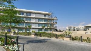 an apartment building with a walkway in front of it at Vida Marina marassi hotel apartment with extra fees for beach or pool access شقة فندقية عائلات فقط في أوتيل فيدا مراسي مارينا دخول شاطئ البحر او حمام السباحة برسوم إضافية in El Alamein