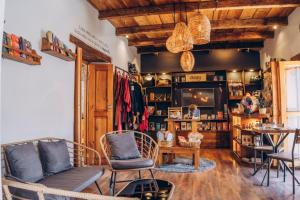 a living room with two chairs and a television at Hospedaje Boutique Paz Creativa in San Cristóbal de Las Casas