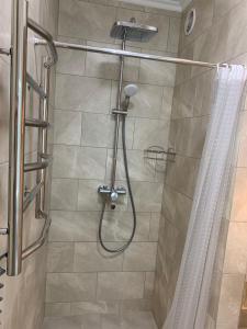 een douche met een douchegordijn in de badkamer bij Coffee Room in Odessa