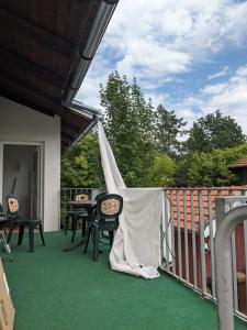 a patio with a table and chairs on a balcony at Maisonette mit Kaminöfen Nähe Starnberger See und München in Münsing am Starnberger See +8 photos