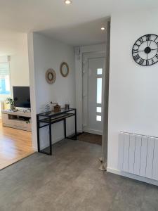 a room with a table and a clock on the wall at Etape du pont du canal in Lupstein