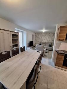 Großes Zimmer mit einem großen Holztisch und Stühlen. in der Unterkunft Belle maison au bord du plan d'eau in Saint-Jean-dʼAngély