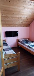 two bunk beds in a room with wooden ceilings at Békény Kulcsosház in Gheorgheni