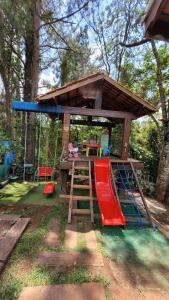 a play house with a slide and a playground at Chalés Senhor Dos Trilhos in Mairiporã