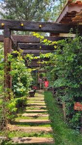 a garden with a wooden pergola and a pathway at Chalés Senhor Dos Trilhos in Mairiporã
