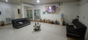 a living room with two couches and a tv at Hotel el CRISTAL Muzo in Muzo