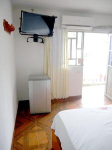 a bedroom with a bed and a tv on the wall at Hotel el CRISTAL Muzo in Muzo +30 photos