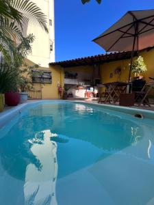 - une piscine d'eau bleue en face d'un bâtiment dans l'établissement Casa Amarela Hostel & Bistrô, à Salvador