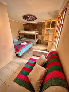 a bedroom with a bed and a couch in a room at Cabañas San Pedro de Atacama. in San Pedro de Atacama