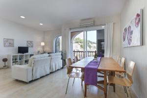 a living room with a dining room table and a couch at Arenyslux II in Arenys de Mar
