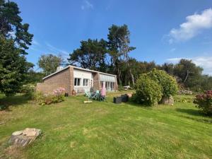 une petite maison dans un champ avec une cour dans l'établissement Parenthèse Océane Suite calme 1 ou 2 chambres entre bois et mer, à Perros-Guirec