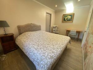 une chambre avec un lit, un bureau et une table dans l'établissement Parenthèse Océane Suite calme 1 ou 2 chambres entre bois et mer, à Perros-Guirec