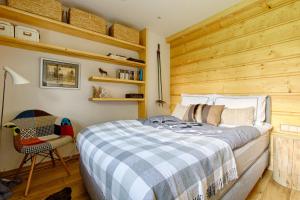 1 dormitorio con 1 cama y pared de madera en Apartament Chałubińskiego, en Zakopane