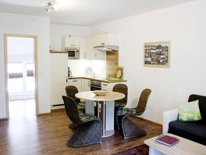 a living room with a table and chairs and a kitchen at Holiday apartment Villa Sonja in Zützen