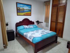 辛塞莱霍Hotel Tamaulipas Mixteca的卧室里的一张床，墙上挂着一幅画