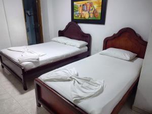 辛塞莱霍Hotel Tamaulipas Mixteca的墙上画画的房间里设有两张单人床 更多1张照片